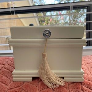 Small white wooden jewelry box with tassel